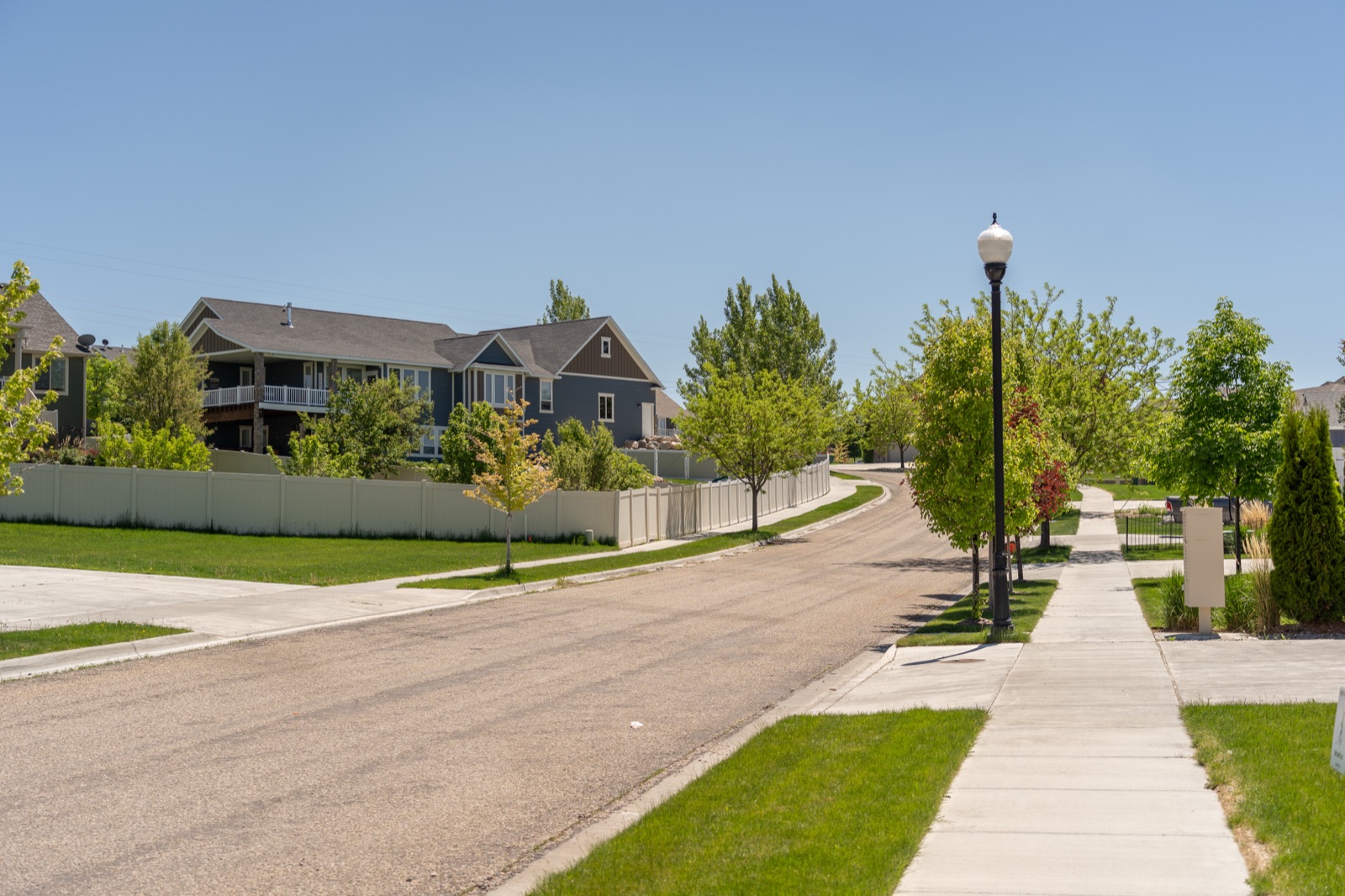 Tree-lined walking path along a quiet street in Hawks Landing